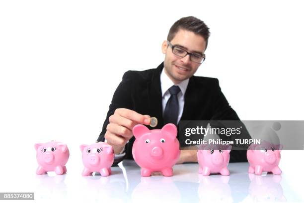 france, young man in costume, money boxes on a table in front of him. - capitalism stock pictures, royalty-free photos & images