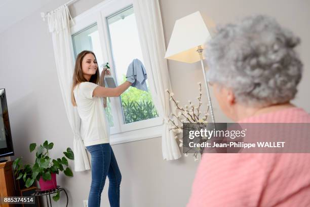 cheerful young girl helping with household chores elderly woman at home. - brand advocacy stock pictures, royalty-free photos & images