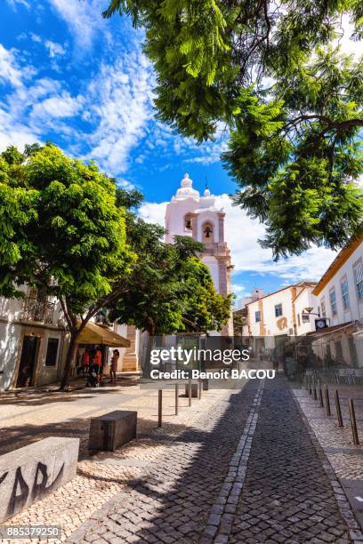 overlooking the cobbled street and church in the town of burgau, algarve region, portugal - burgau portugal stock pictures, royalty-free photos & images