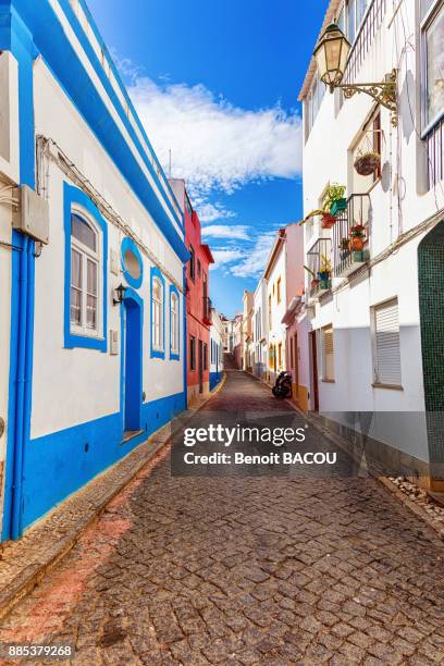 view of a cobblestone street, town of burgau, algarve region, portugal - burgau portugal stock pictures, royalty-free photos & images
