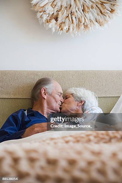 a senior couple having a kiss - pecking stockfoto's en -beelden