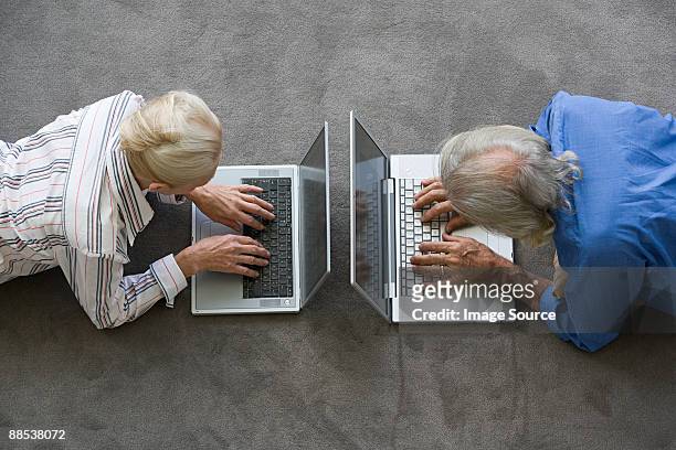senior couple using laptops - china foto e immagini stock