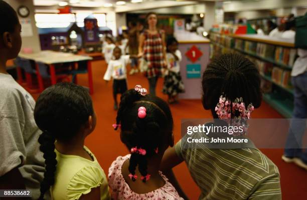 Homeless children watch as other homeless youth arrive to watch a free clown show at the Dallas Public Library on June 17, 2009 in Dallas, Texas. The...