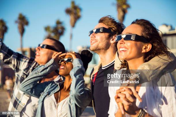 vrienden in santa monica - los angeles plezier op de promenade - solar eclipse stockfoto's en -beelden