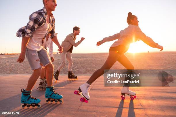 amigos en santa mónica - los ángeles que se divierten en el paseo marítimo - patín de ruedas fotografías e imágenes de stock