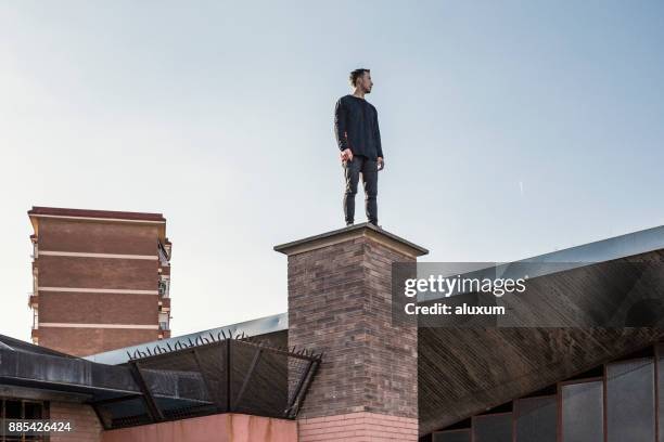 man practicing parkour in the city - man on top of building stock pictures, royalty-free photos & images