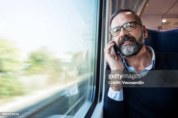 empresario maduro en tren - passenger train fotografías e imágenes de stock