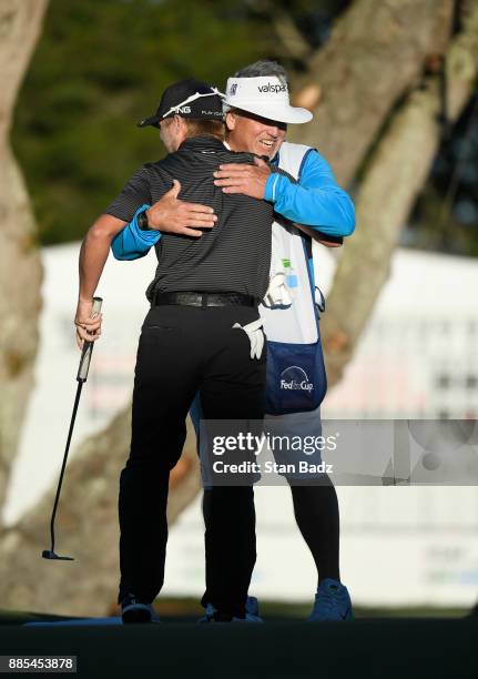 Austin Cook celebrates with his caddy on the 18th green during the final round of The RSM Classic at the Sea Island Resort Seaside Course on November...