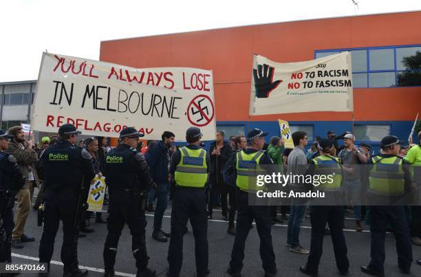 Members of Campaign Against Racism and Fascism hold a banner reading "You'll Always Lose In Melbourne" including a Nazi sign crossed out during a...