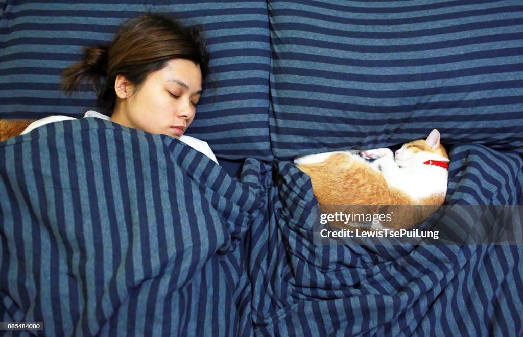 Girl sleep with her ginger cat