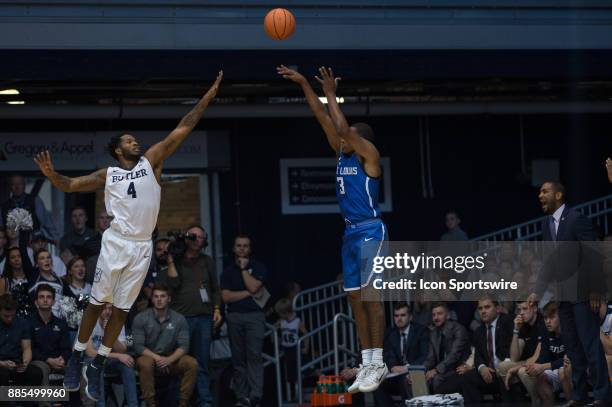 Saint Louis Billikens guard Javon Bess shoots a three pointer over Butler Bulldogs forward Tyler Wideman during the men's college basketball game...