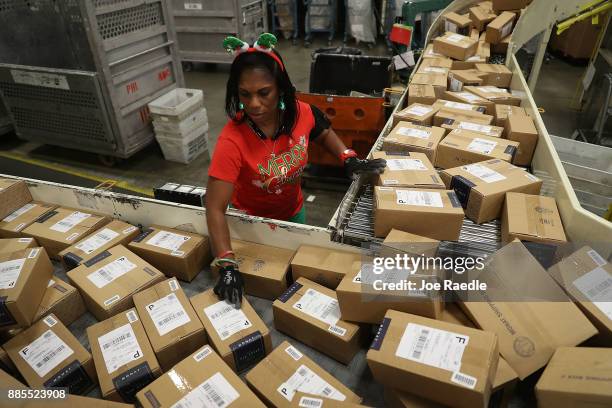 Postal service mail handler Barbara Lynn sorts boxes at the U.S. Postal service's Royal Palm Processing and Distribution Center on December 4, 2017...
