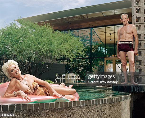 fit couple posing by the pool - two elderly men dressed in 70's outfits stock pictures, royalty-free photos & images