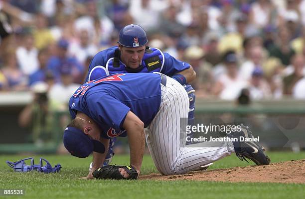 Pitcher Jason Bere of the Chicago Cubs is injured as catcher Todd Hundley looks on against the Cincinnati Reds during the game on June 26, 2002 at...