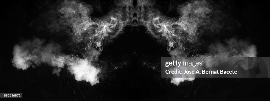Forms and textures of an explosion of smoke and powder of white color on a  black background.