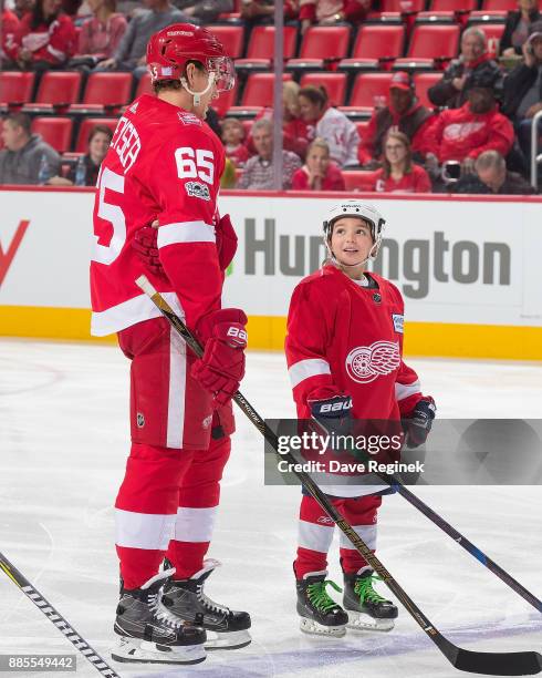 Danny DeKeyser of the Detroit Red Wings greets the youth skater of the game prior to an NHL game against the Montreal Canadiens at Little Caesars...