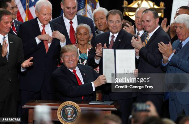 With Utah officials surrounding him, U.S. President Donald Trump shows an executive order he signed reducing the Grand Staircase-Escalante National...