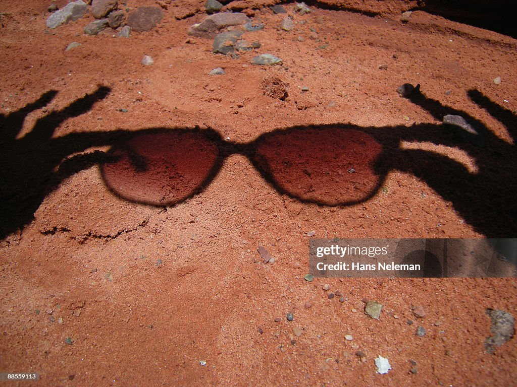 Shadow of a person holding sunglasses