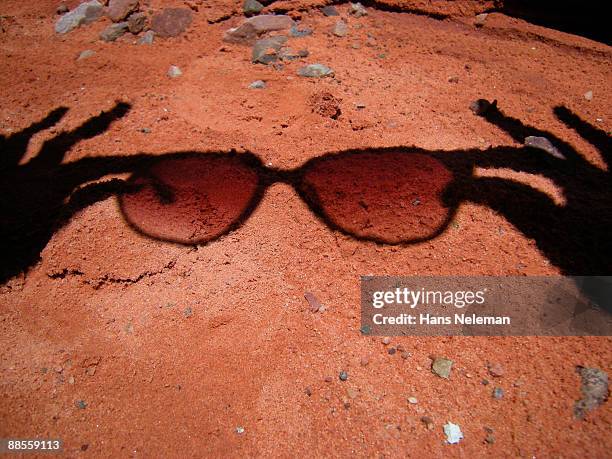 shadow of a person holding sunglasses - hands red soil stock pictures, royalty-free photos & images