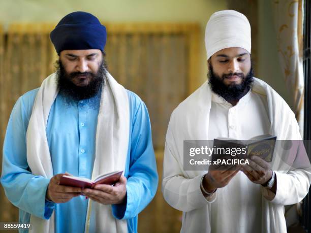 two sikh diciples holding a prayer service. - sikh foto e immagini stock