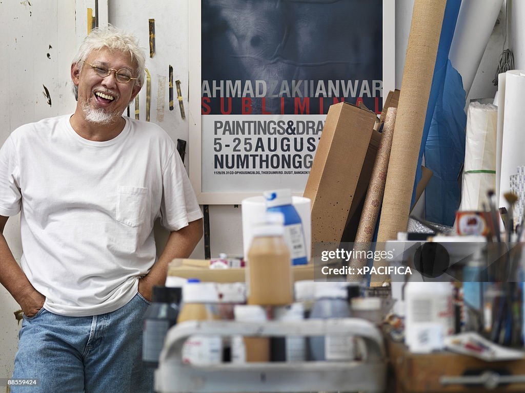 A portrait of an artist standing in his studio 