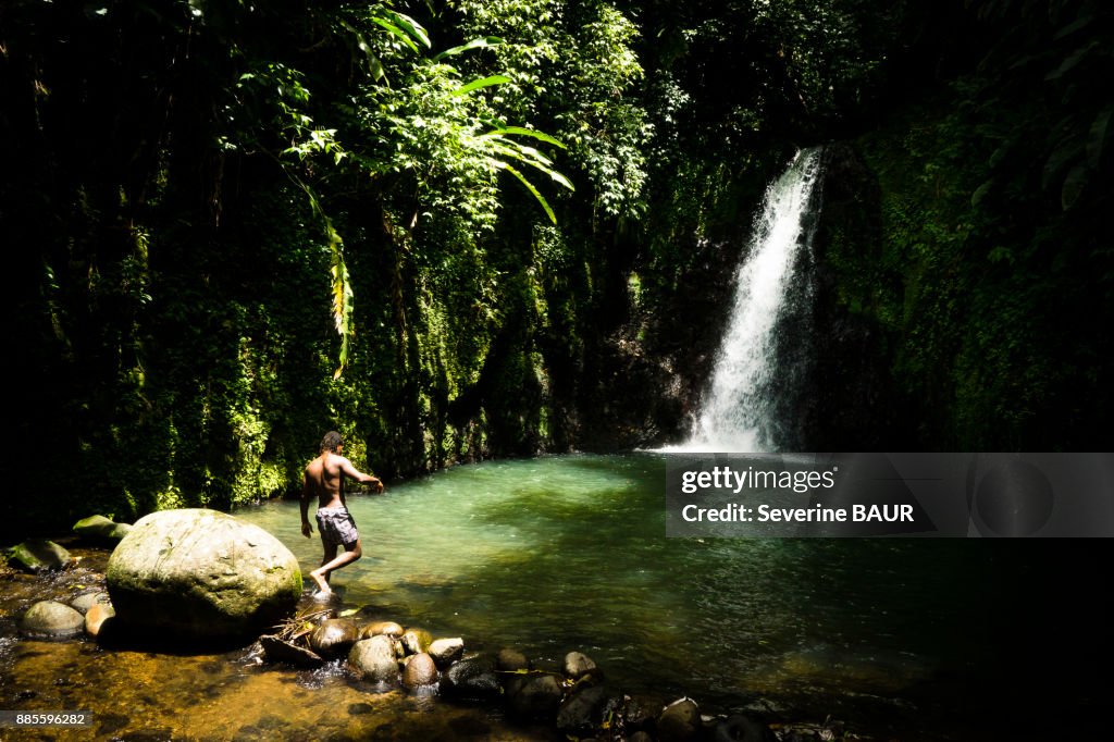 A young man in front of the Seven sisters waterfall, Grenada, West Indies