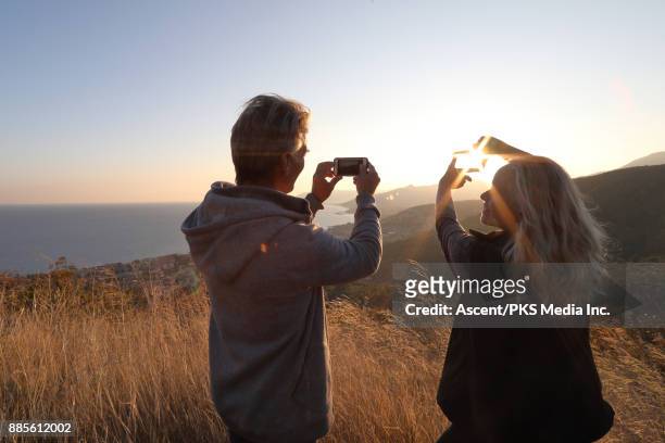 mature couple take pic from grassland overlook, above sea - photo messaging foto e immagini stock