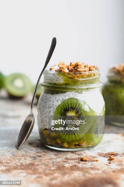 chia pudding with kiwi, granola and almonds in a jar - kiwi fruit stock pictures, royalty-free photos & images