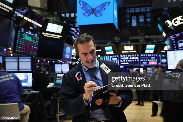 Traders work on the floor of the New York Stock Exchange at the end of the trading day on December 4, 2017 in New York City. Banks and retailers...