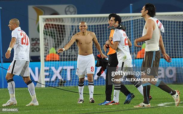 Italian forward Luca Toni walks past Egyptian forward Wael Gomaa , Egyptian forward Mohamed Zidan and Egytpian forward Mohamed Aboutrika celebrating...