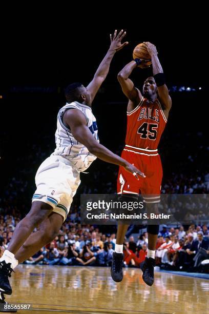 Michael Jordan of the Chicago Bulls shoots a jump shot against Larry Johnson of the Charlotte Hornets in Game Two of the Eastern Conference...