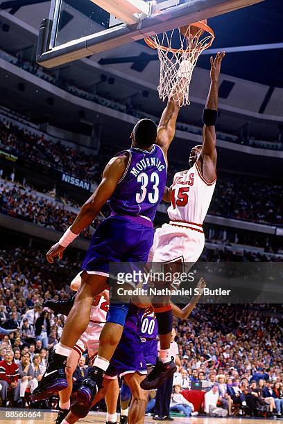 Michael Jordan of the Chicago Bulls shoots a layup against Alonzo Mourning of the Charlotte Hornets in Game Three of the Eastern Conference...