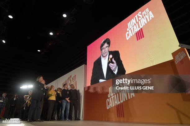 'Junts per Catalonia' grouping cadidate for the upcoming Catalan regional election, Carles Puigdemont, appears on a screen to take part in the...