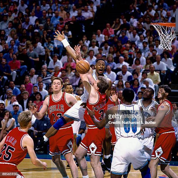 Alonzo Mourning of the Charlotte Hornets fights for a rebound against Bill Wennington of the Chicago Bulls in Game One of the Eastern Conference...