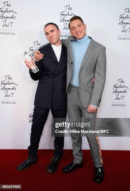 Raf Simons with the Designer of the Year Award and presenter Oliver Sim in the winners room during The Fashion Awards 2017 in partnership with...