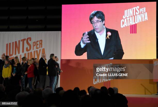 'Junts per Catalonia' grouping cadidate for the upcoming Catalan regional election, Carles Puigdemont, appears on a screen to take part in the...