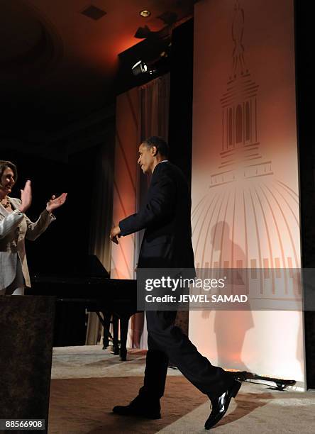 House Speaker Nancy Pelosi greets US President Barack Obama on stage as he arrives to speak at the Democratic Senatorial Campaign...