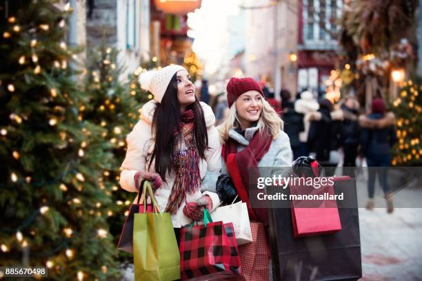 christmas shopping with two young women - holiday spirit stock pictures, royalty-free photos & images