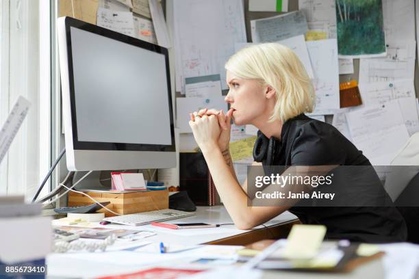 female designer staring from office desk - leaning on elbows stock pictures, royalty-free photos & images