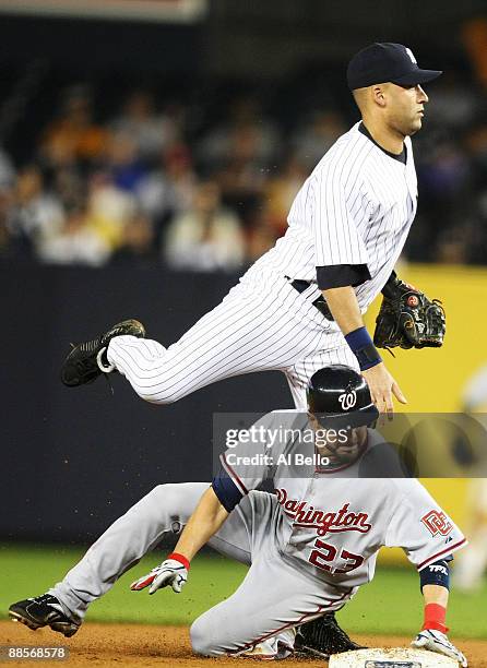 Derek Jeter of the New York Yankees avoids the slide of Wil Nieves of the Washington Nationals during their game on June 18, 2009 at Yankee Stadium...