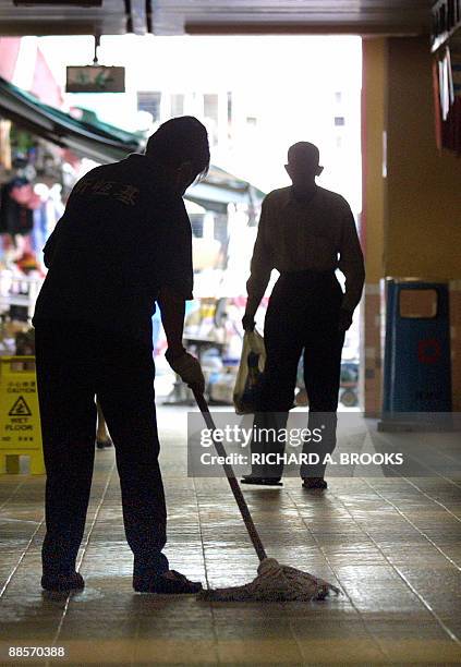 Cleaner mops a floor across from Wing Shui House at Lek Yuen Estate in the Sha Tin district of Hong Kong on May 23, 2003. Chinese state media has...