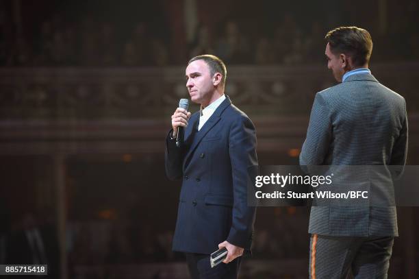 Oliver Sim presents Raf Simons with his award on stage during The Fashion Awards 2017 in partnership with Swarovski at Royal Albert Hall on December...