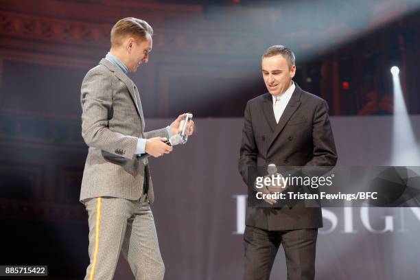 Oliver Sim presents Raf Simons with his award on stage during The Fashion Awards 2017 in partnership with Swarovski at Royal Albert Hall on December...