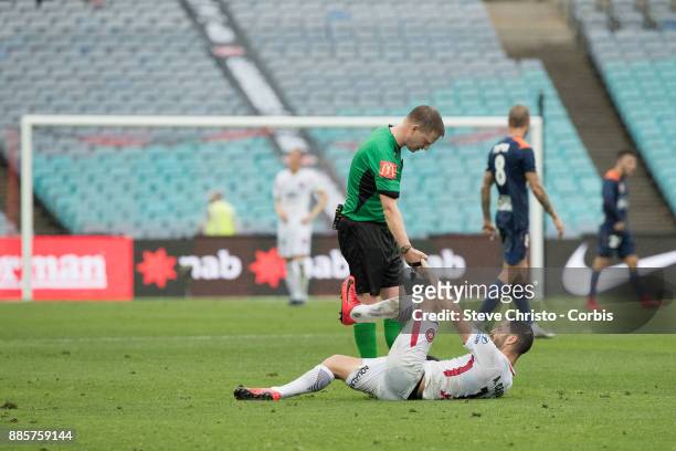 Alvaro Cejudo of the Wanderers is helped to his feet by referee Adam Fielding after being heavily tackled during the round nine A-League match...