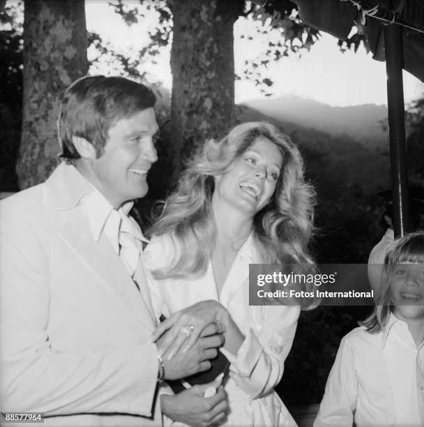 Just-married American actors Lee Majors and Farrah Fawcett laugh as they show off Farrah's wedding ring at the reception following their marriage at...