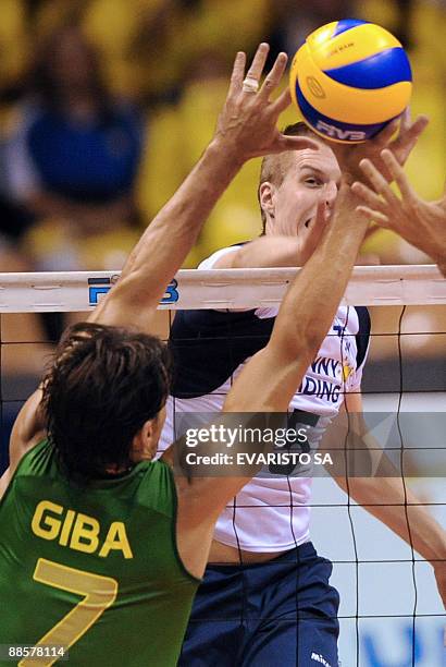 Finnish Matti Oivanen spikes the ball over Brazilian Gilberto Giba Godoy during their World League Volleyball first match in Brasilia on June 19,...