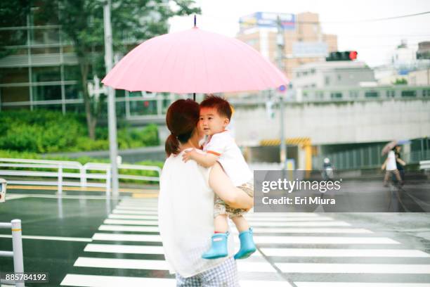 rainy in tokyo. - mother son shower stockfoto's en -beelden