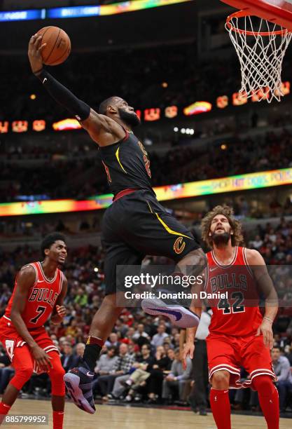 LeBron James of the Cleveland Cavaliers goes up for a dunk over Robin Lopez of the Chicago Bulls at the United Center on December 4, 2017 in Chicago,...