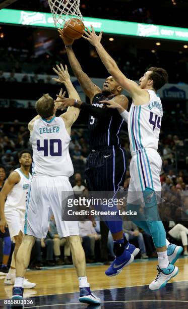 Marreese Speights of the Orlando Magic drives to the basket against teammates Cody Zeller and Frank Kaminsky of the Charlotte Hornets during their...