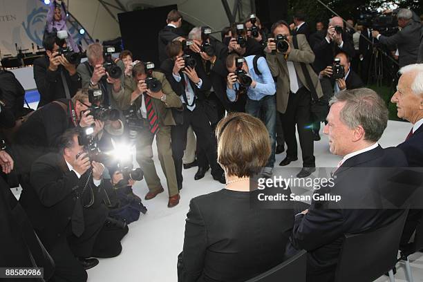 Photographers photograph German President Horst Koehler and his wife Eva Luise Koehler as they attend the presidential summer garden party at...